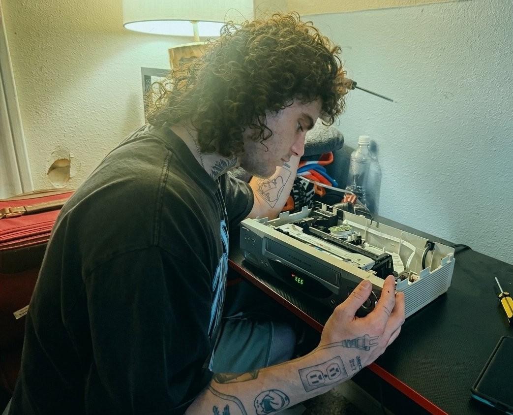 Clayton repairing a VCR in the shop
