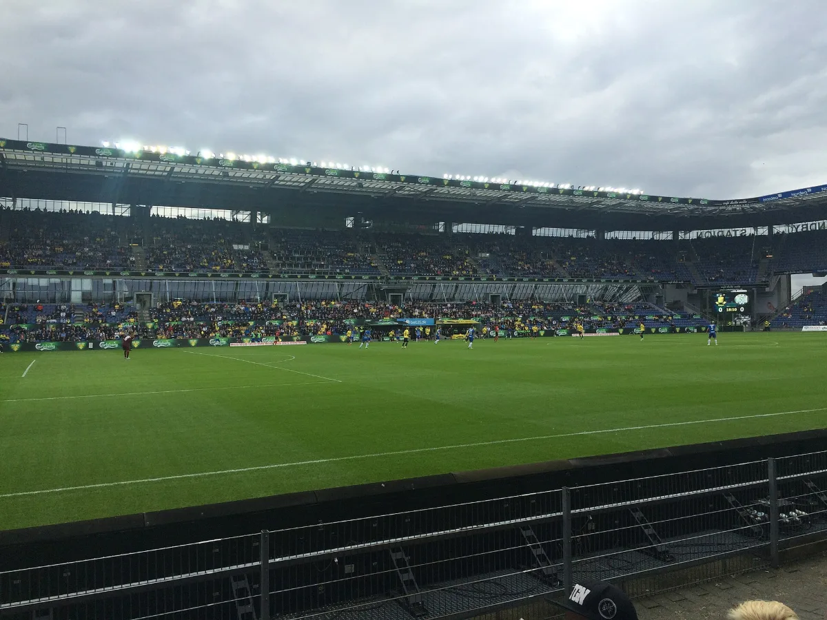Inside Brøndby Stadion in July 2016: blue seats, yellow-clad supporters and players on the pitch